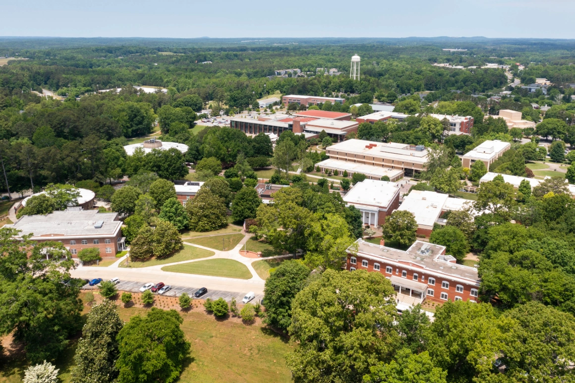 Aerial drone photograph of campus looking into campus from above front campus drive, showing various buildings and pathways.