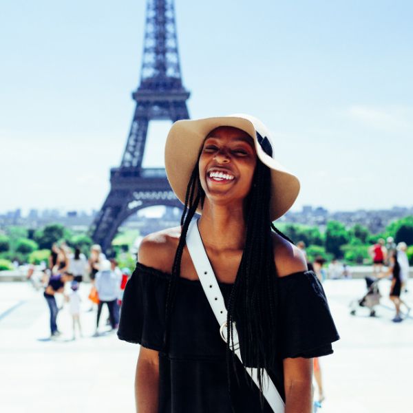 woman smiling in front of eiffel tower