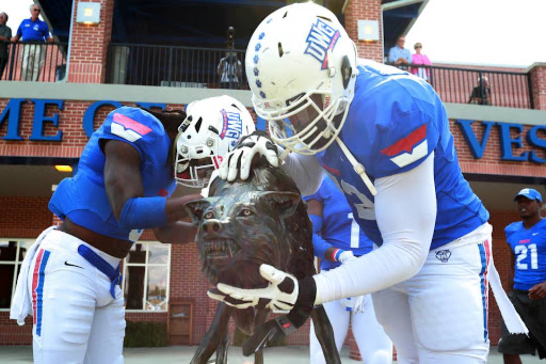 UWG Football Players By Wolf Statue