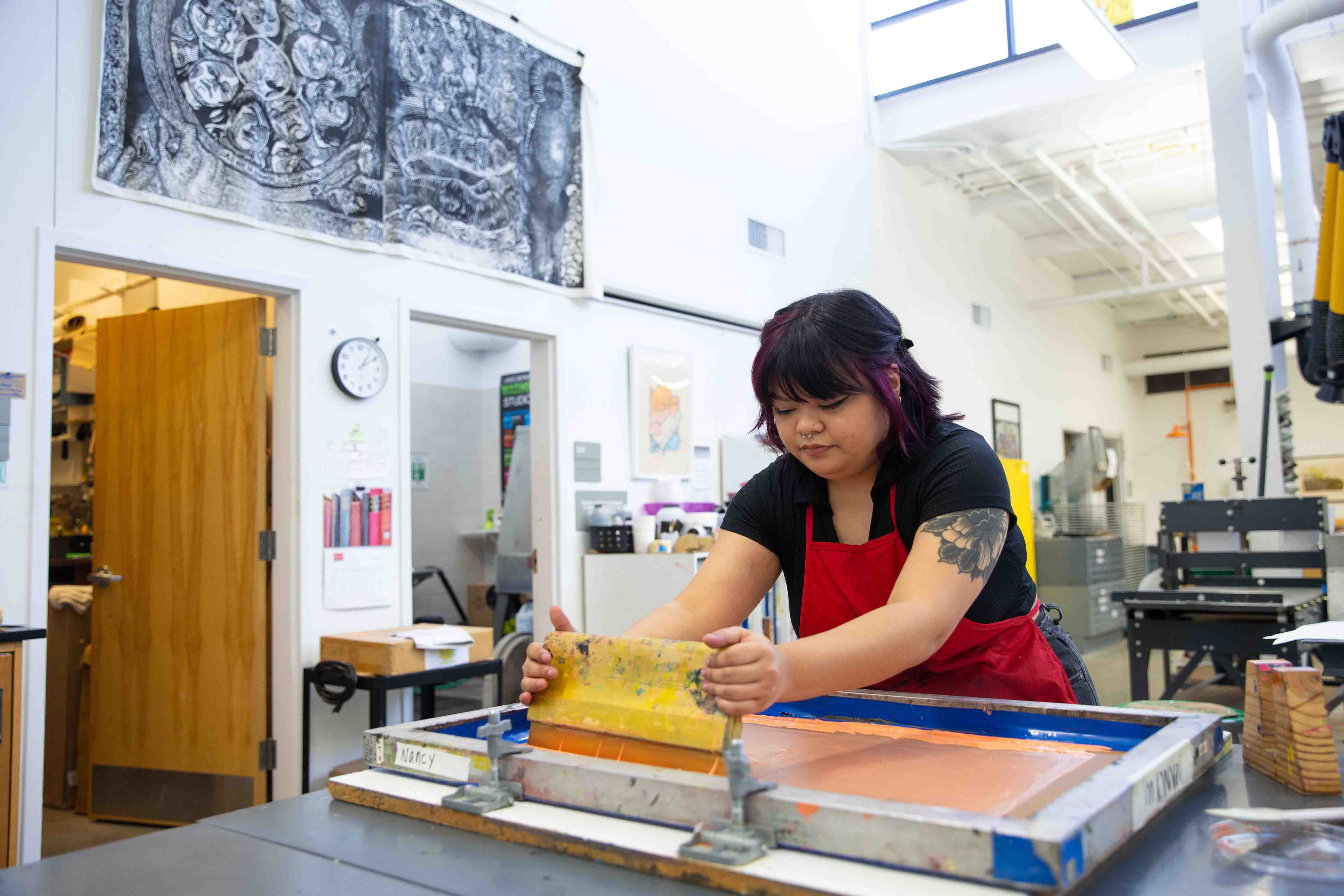 Nancy Vu poses for portraits while doing a screen print in the Visual Arts Building