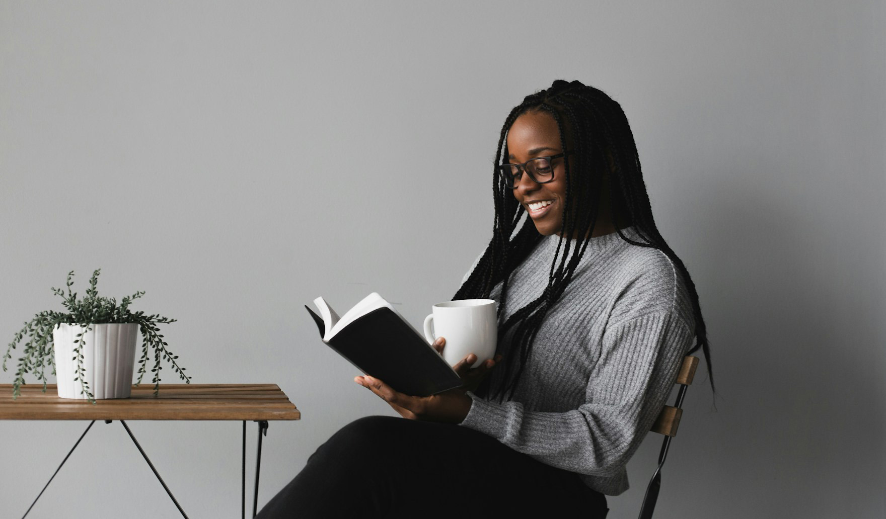 woman sitting with a book and coffee cup in her hands