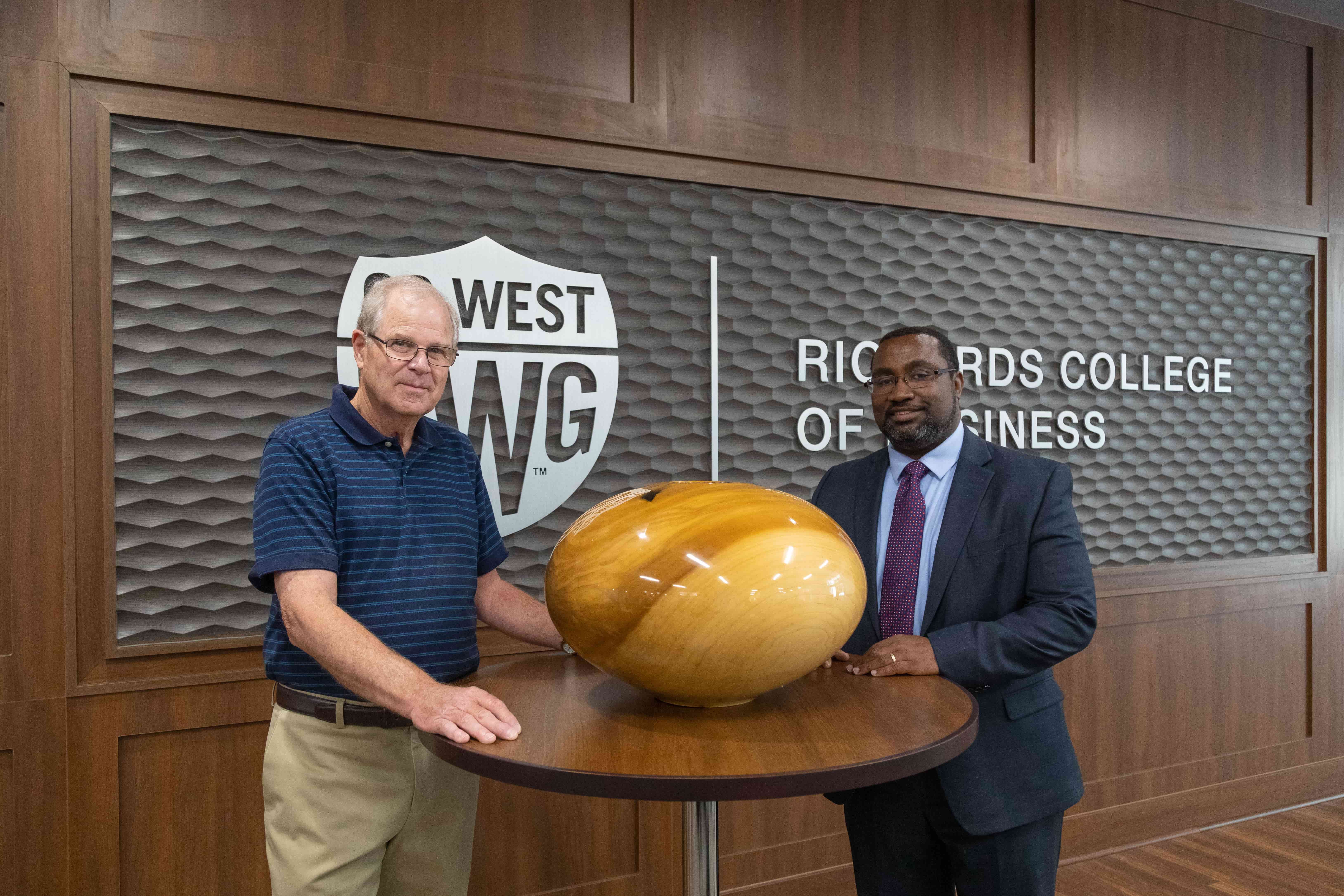 Philip Moultrop and Dr. Fortune stand for a picture next to the finished wood bowl masterfully crafted by Philip.