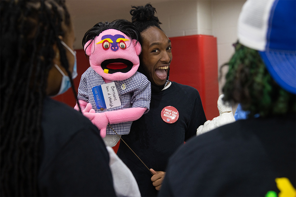 student holding puppet with a button saying "what can I help you become?"