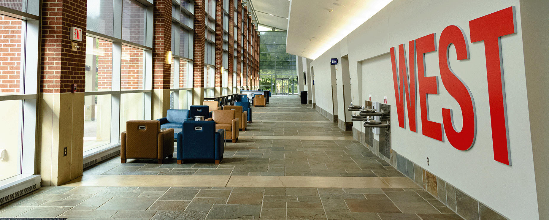 Image of Campus Center atrium with west sign on wall to the right and chairs to the left