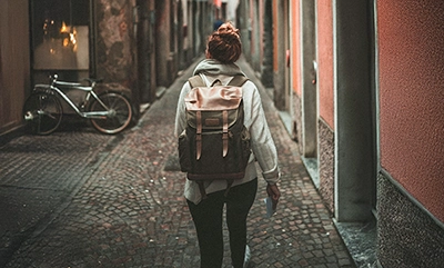student walking down cobblestone European street