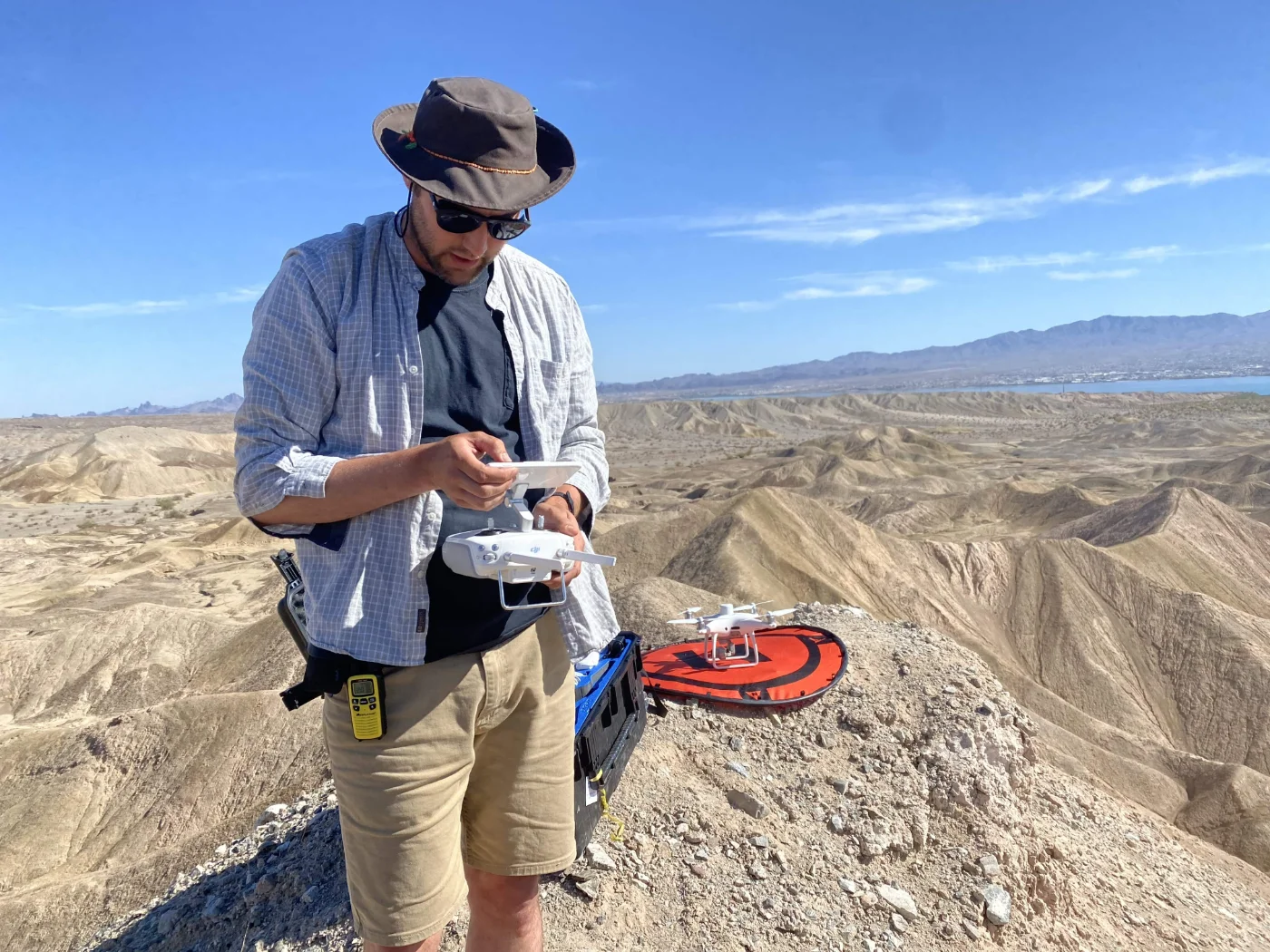 student preparing an aerial drone to survey geological terrain.