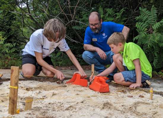 Instructor and campers digging in summer camp