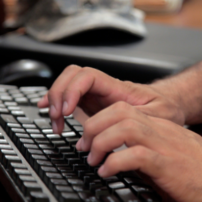 man typing on keyboard for online course