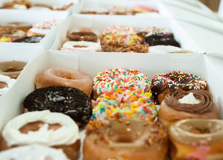 a dozen beautiful donuts in a white box