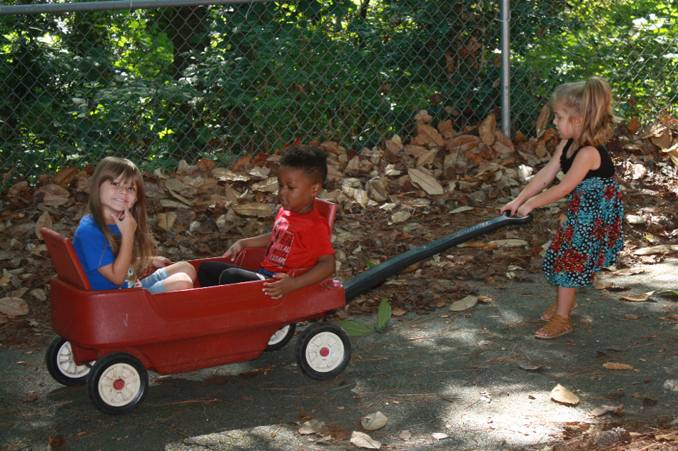 Pre-K students playing in a wagon