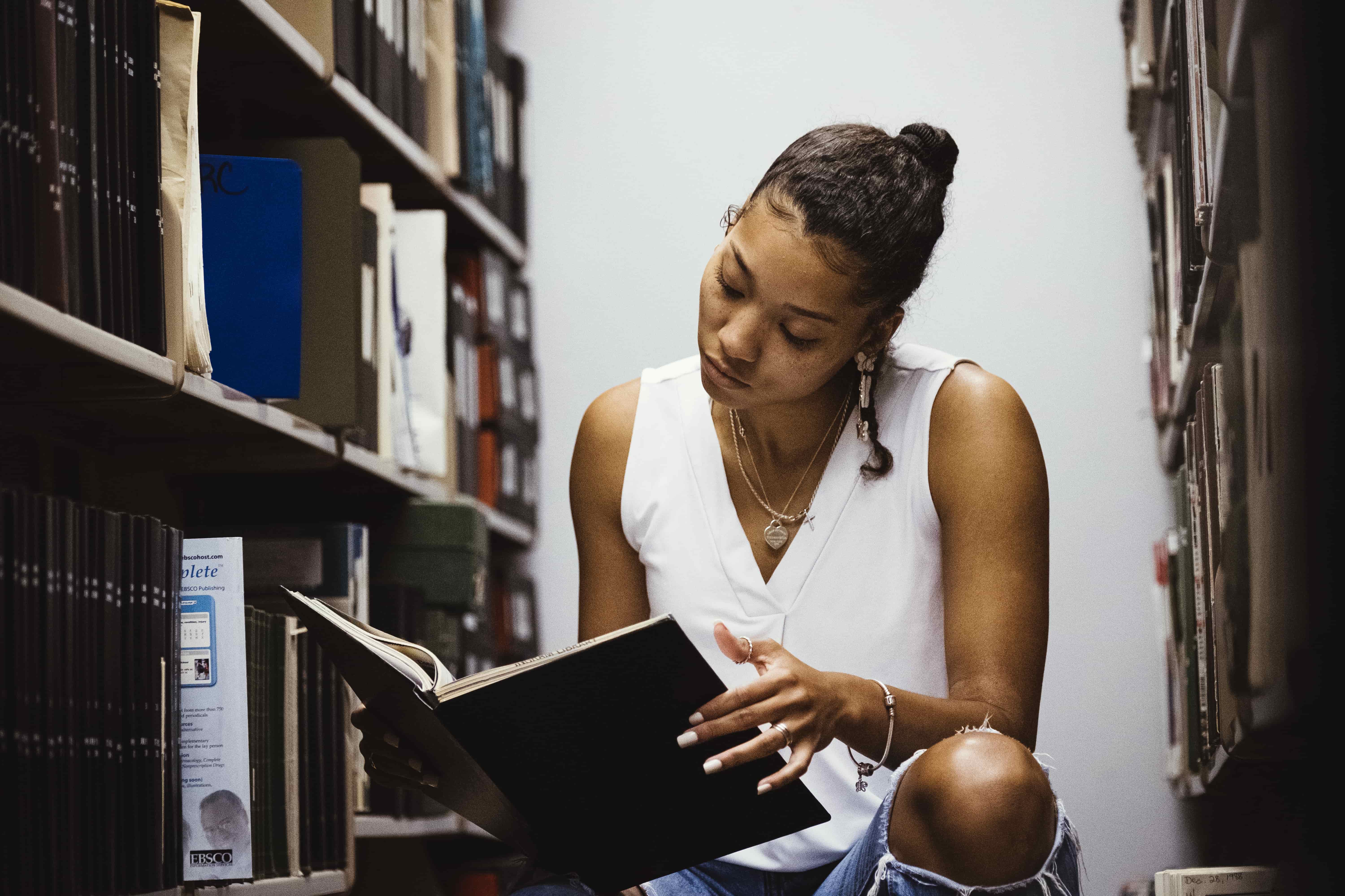 Student in library reading books.