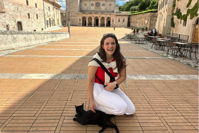 women kneeling on the floor petting a black cat