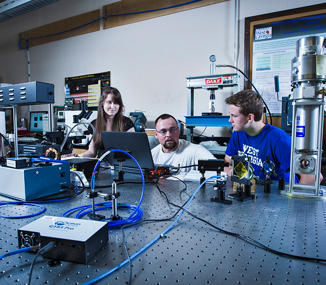Three UWG students performing a physics experiment.