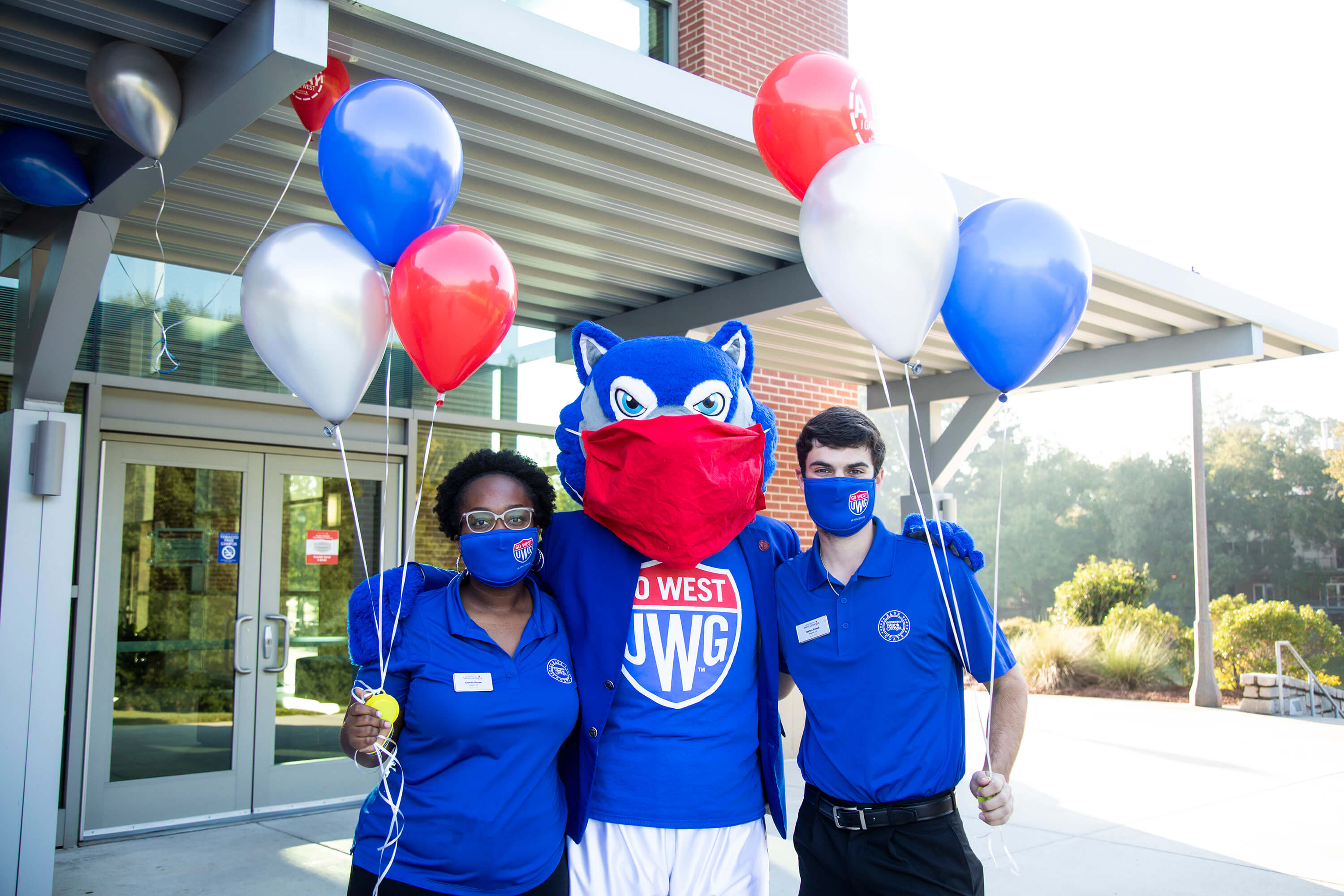 Wolfie and two students with masks