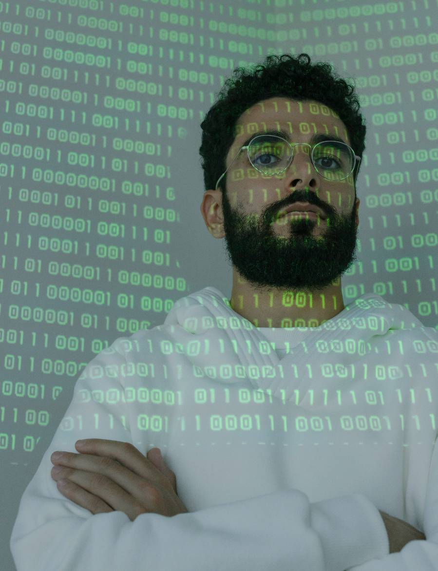 a man standing in front of a projection screen with 1's and 0's