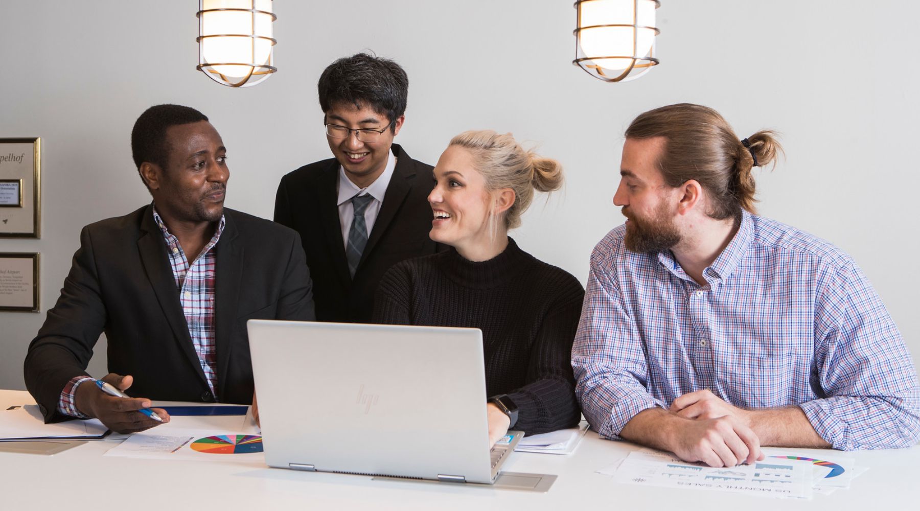 Four students gathered around a computer.