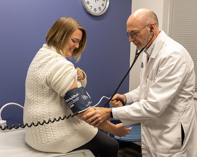 Dr. Heine checking vitals of a staff member patient