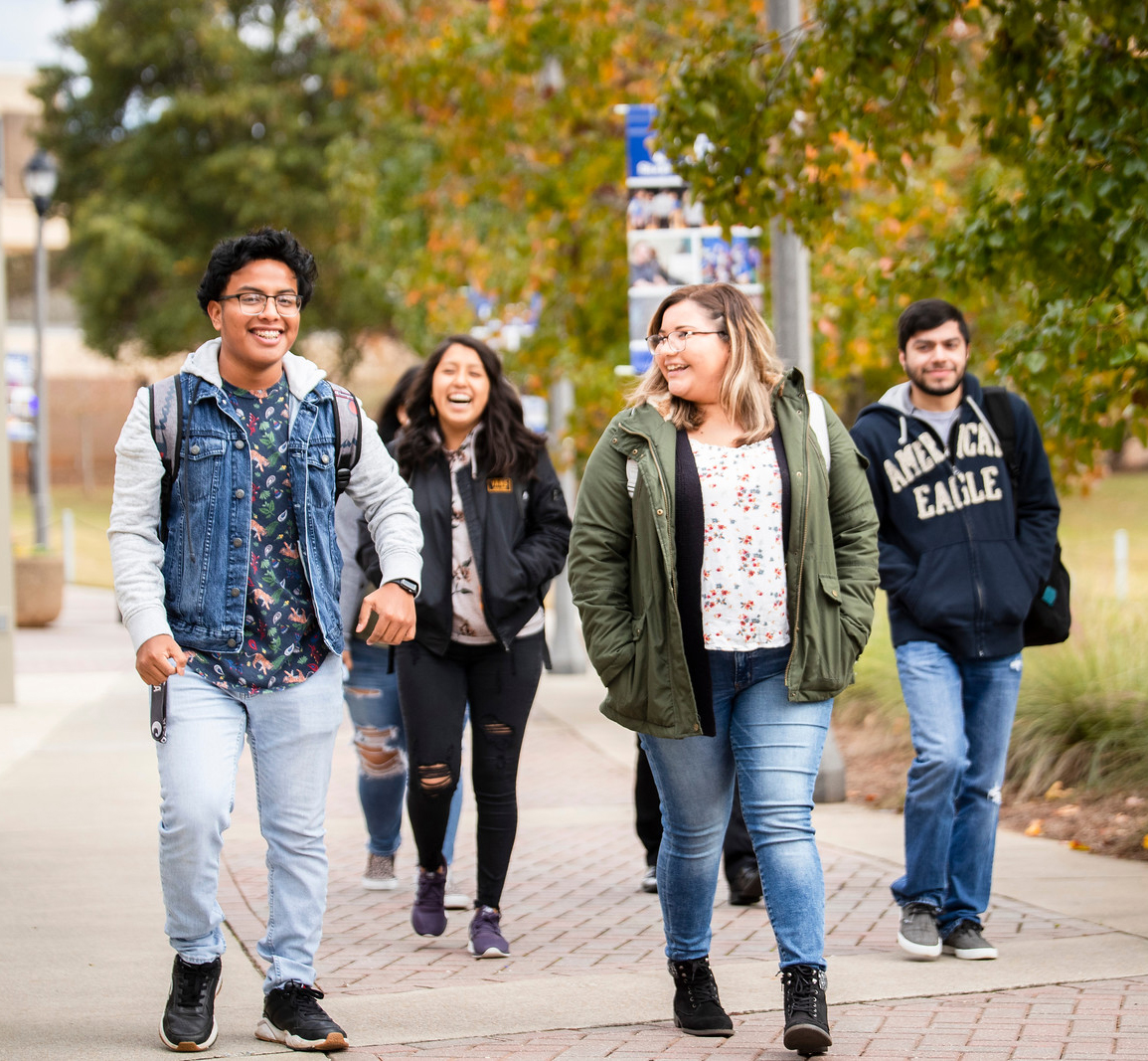 Four students walking through campus