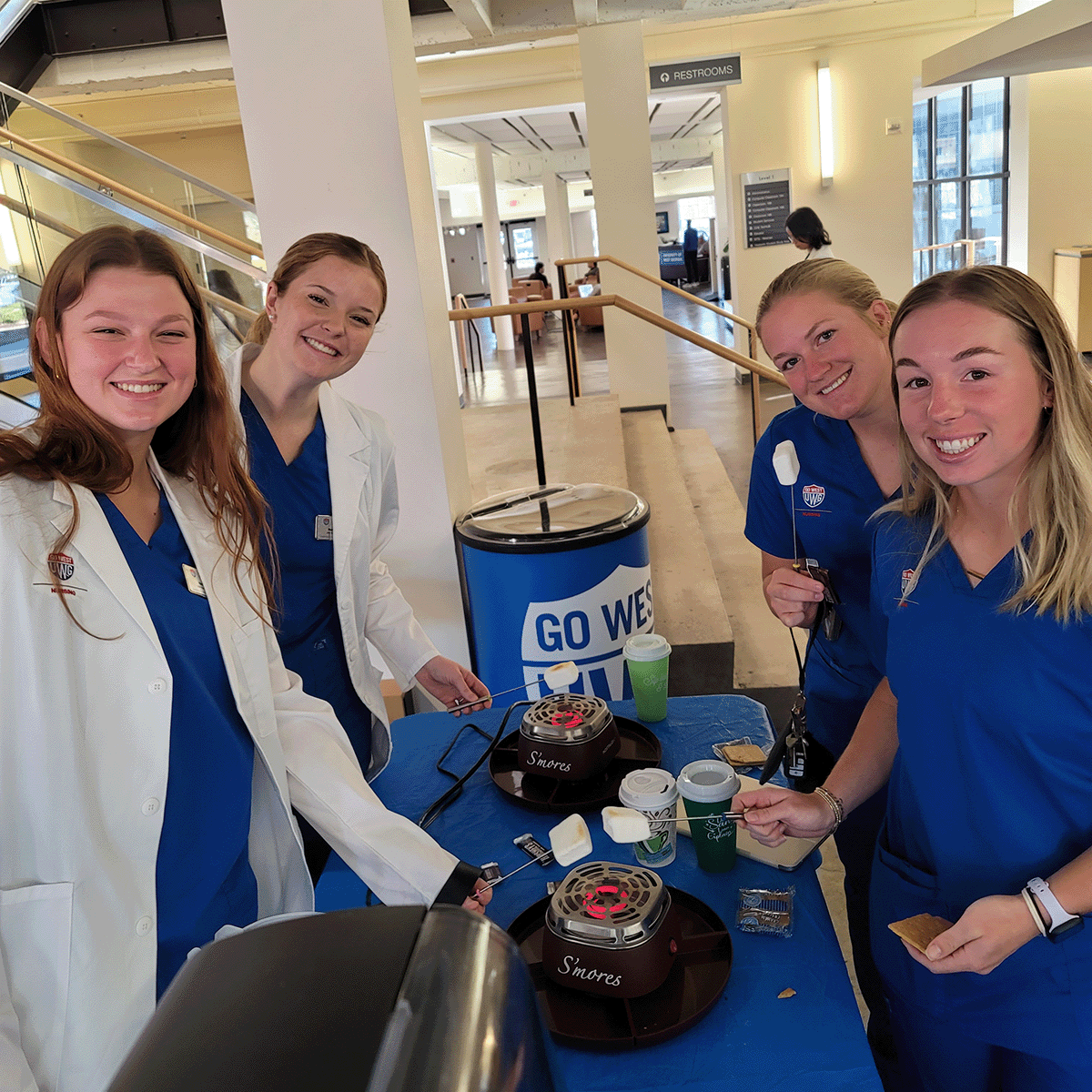Four nurse students making indoor s'mores at the Spread Kindness Newnan event.