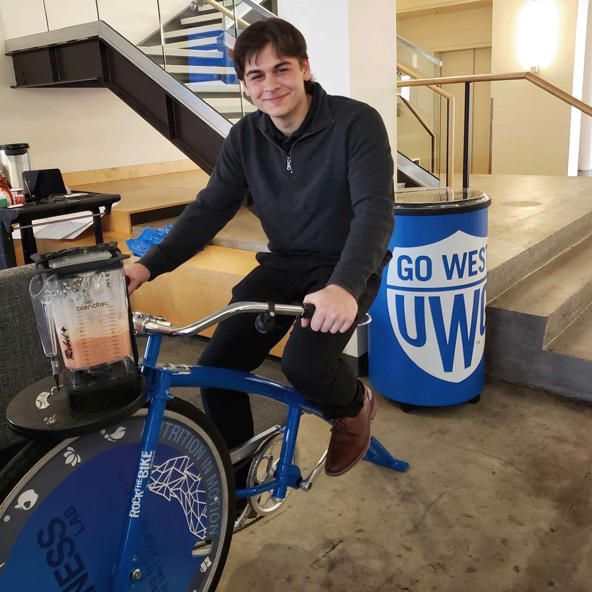 Student on a smoothie bike smiliing