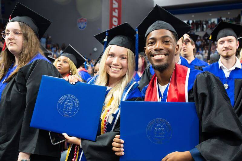 Smiling UWG graduates at commencement