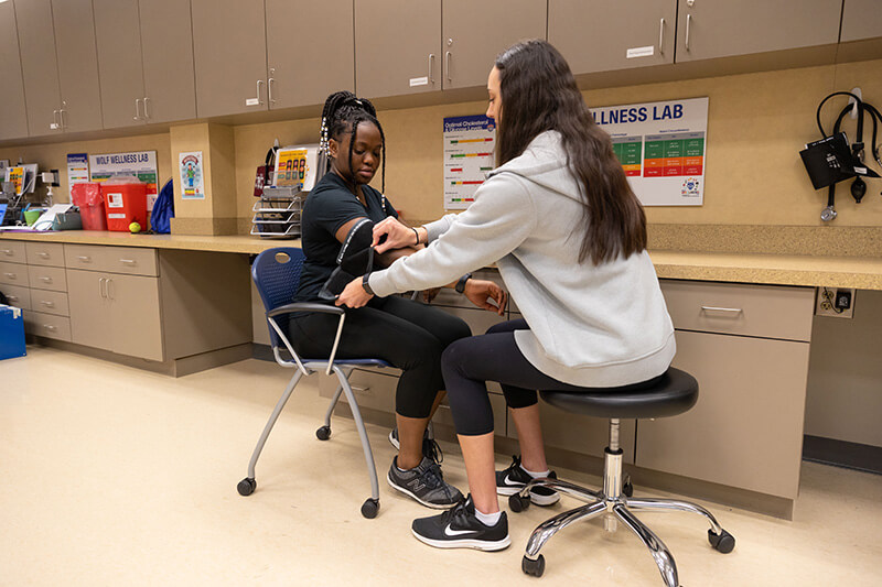 student checks another student's boold pressure