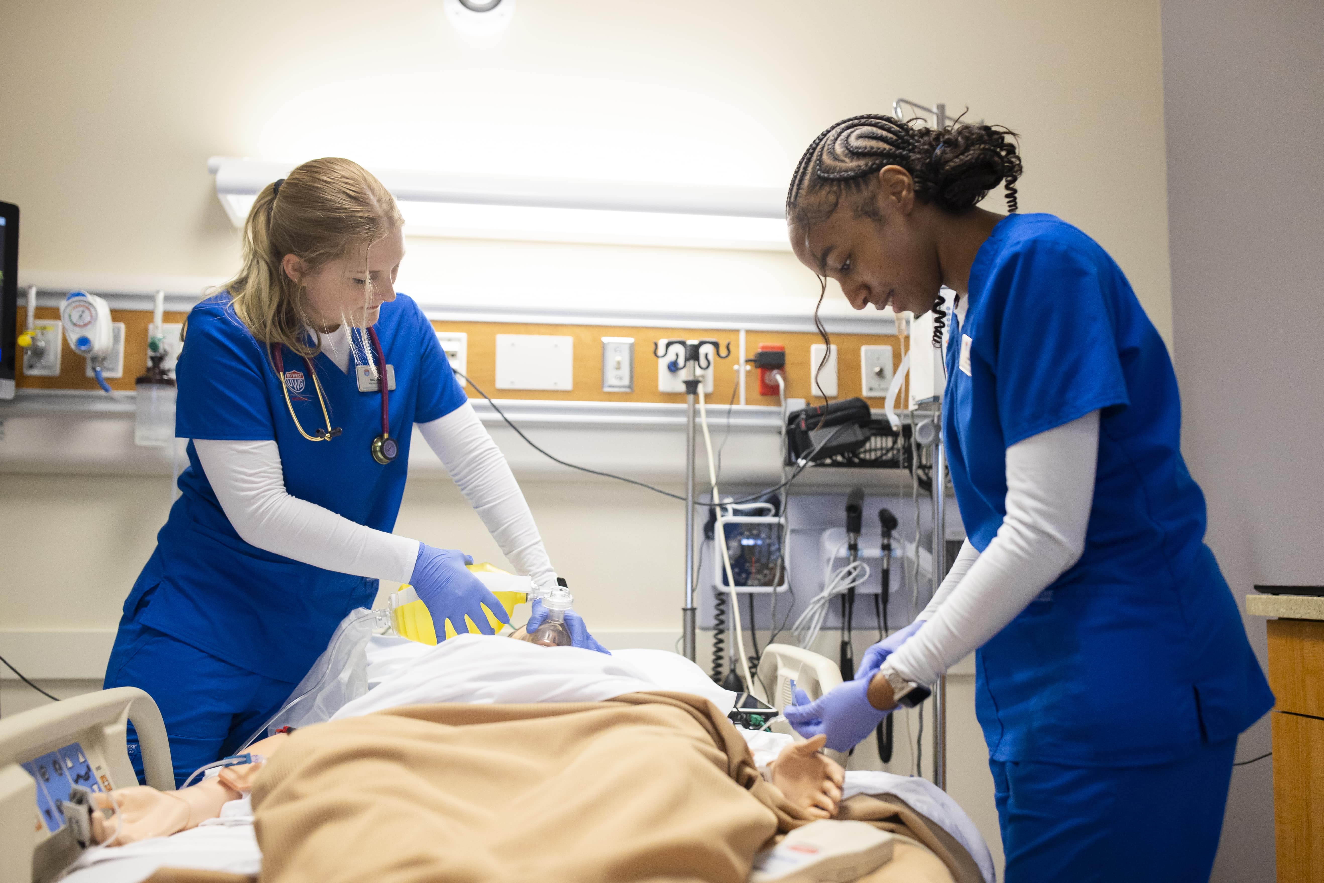 nursing students in an experiental classroom working with an artificial patient