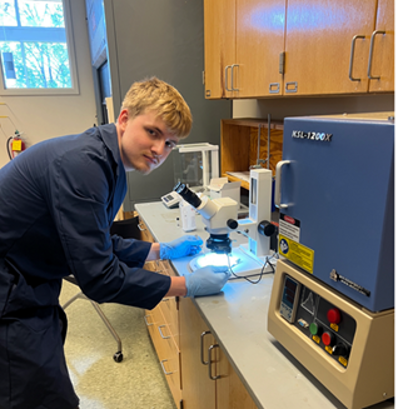 Matthew Stitz posing with microscope
