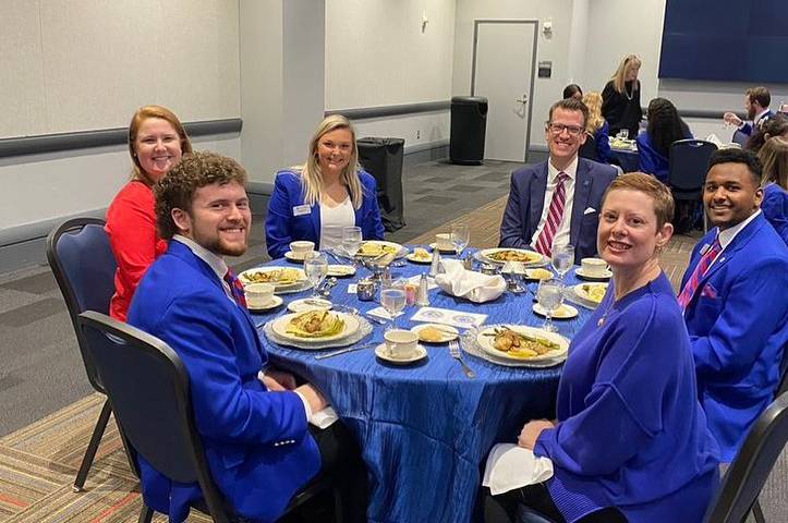 Dr. Kelly sitting at a table with the Blue Coats.