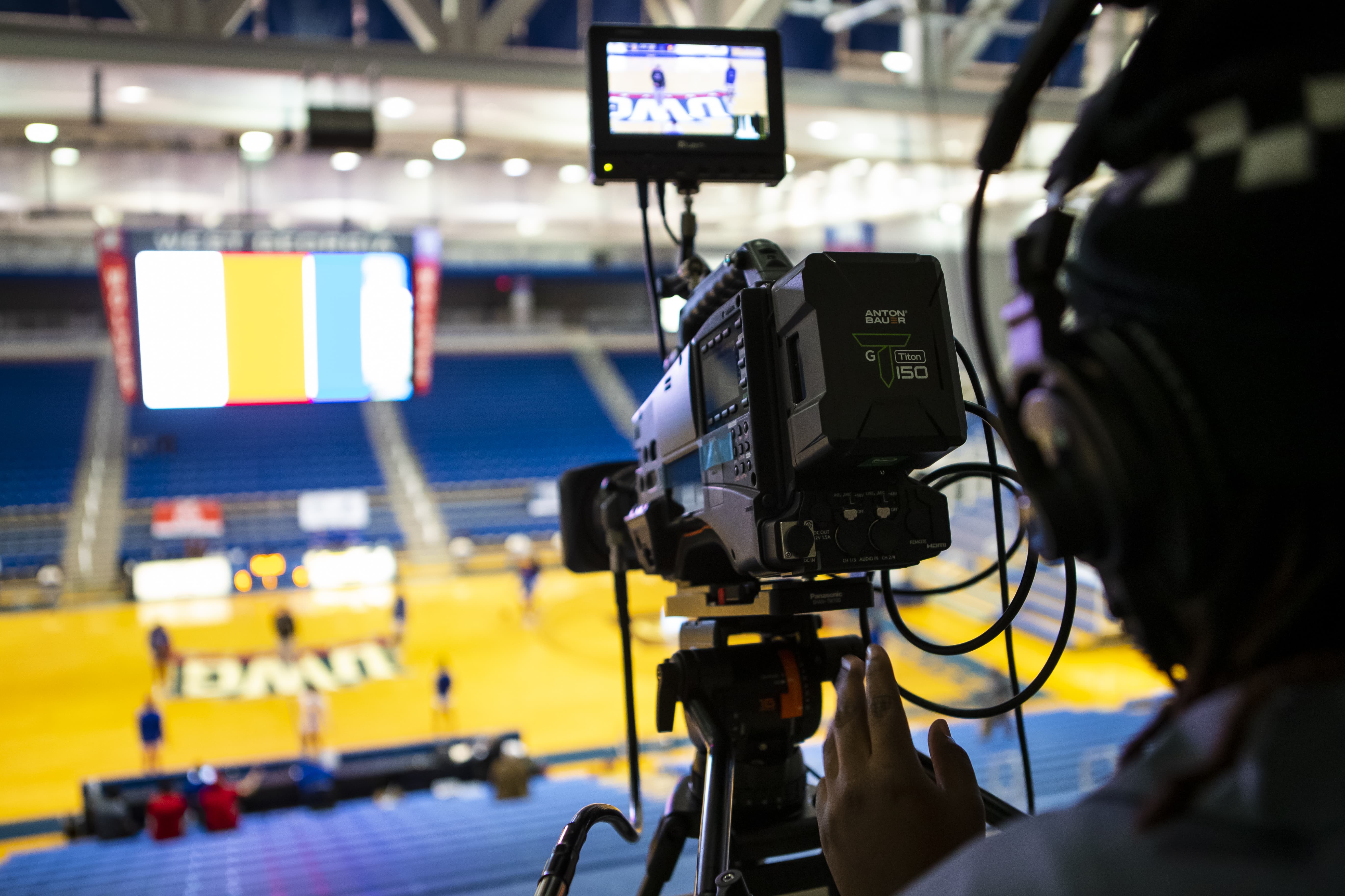 Camera person operating professional camera equipment at a basketball game.