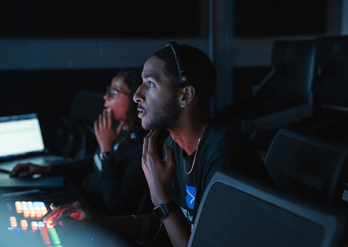 Production students watching and editing footage in the control room.