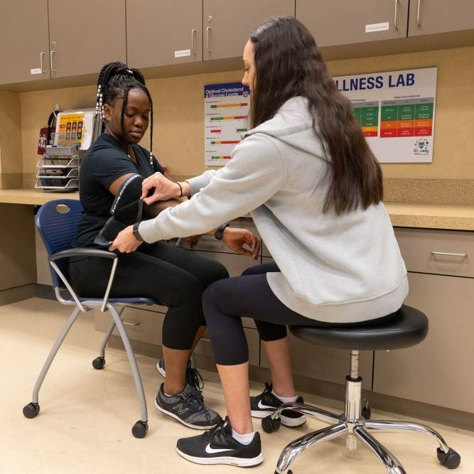 girl taking girls blood pressure