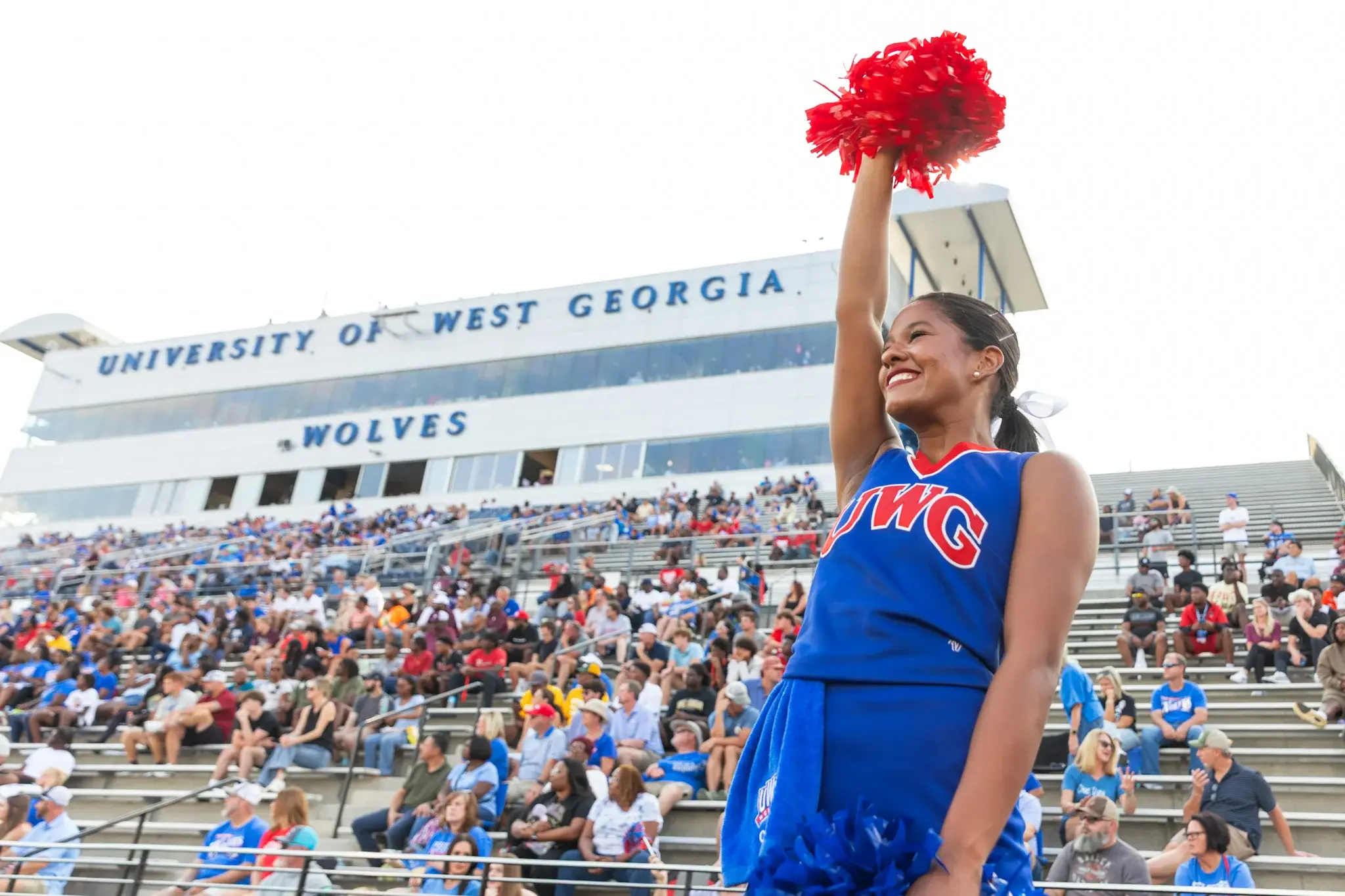 University Stadium during gameday with cheer team in foreground and crowd in stands behind.