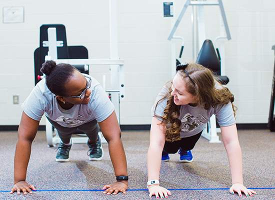 Two UWG students working out at the gym. 