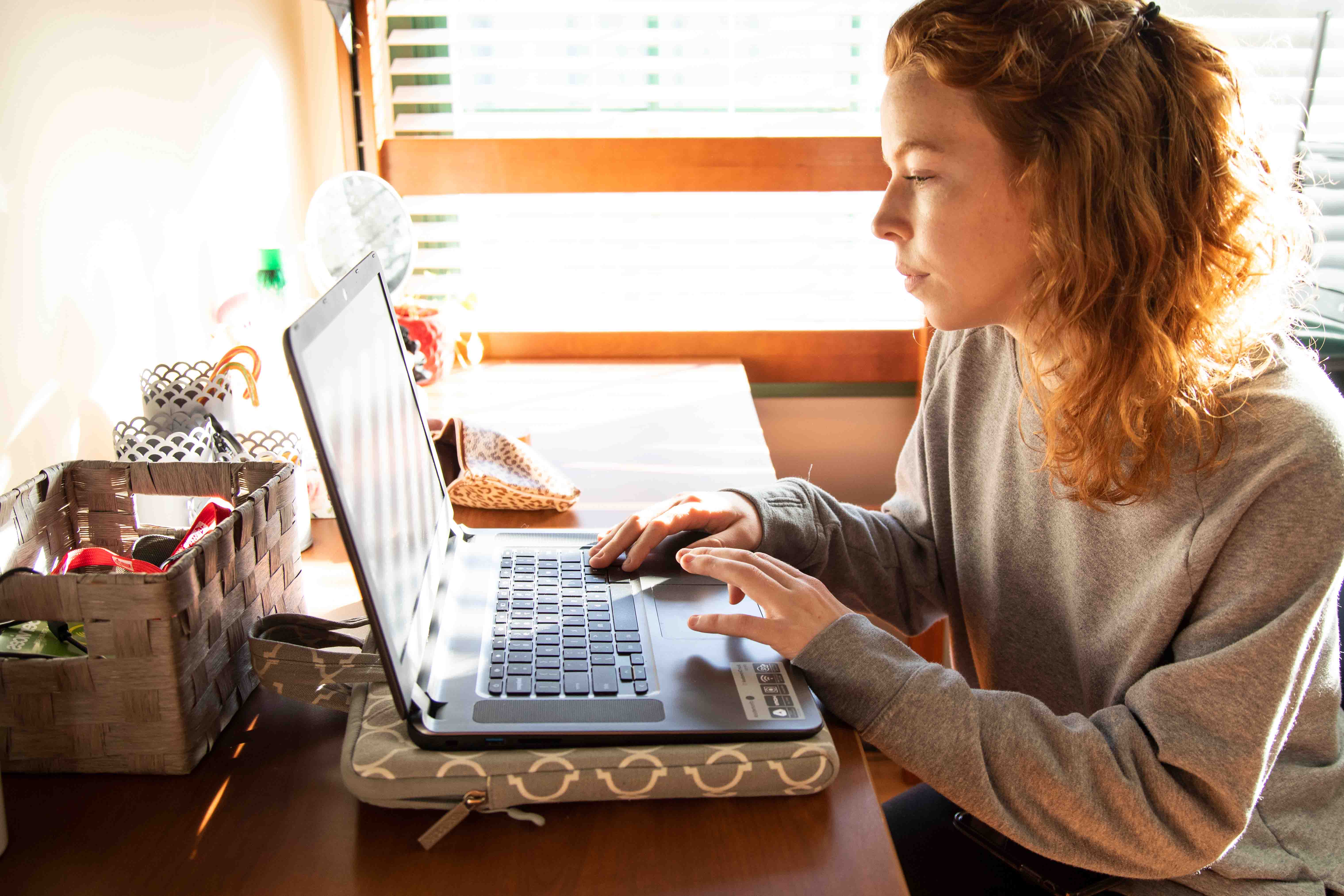 The image is of a female student sitting at a computer