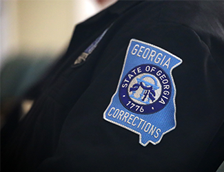 Left sleeve of a Georgia Department of Correction (GDC) employee showing the GDC patch on the sleeve.