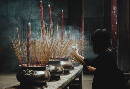 Woman lighting sticks in an Vietnamese temple