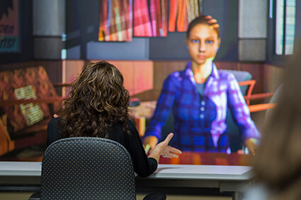 A participant interacting with an adult avatar in a mock parent-teacher conference