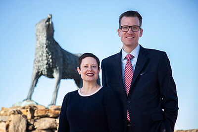 Brendan and Tressa Kelly stand in front of Wolf statue