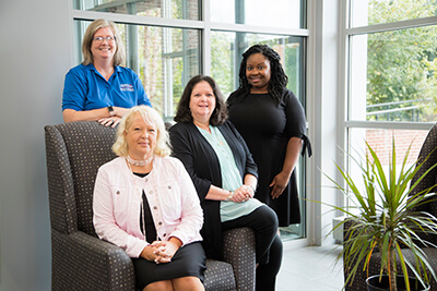 Standing: Dr. Lara Willox. Sitting left-right: Dr. Anne Gaquere-Parker, Myda Iamiceli and LaDonia Patterson.